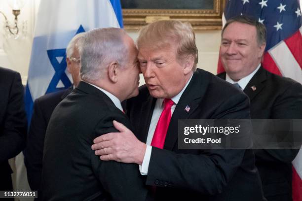 Prime Minister of Israel Benjamin Netanyahu kisses the cheek of US President Donald J. Trump , as US Secretary of State Mike Pompeo looks on; before...