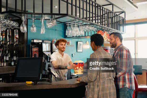 friends buying popcorn for the movie - movie counter stock pictures, royalty-free photos & images