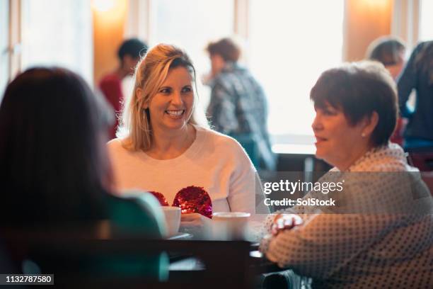 vrouwen genieten van een kopje koffie - book club meeting stockfoto's en -beelden