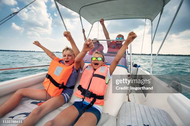 famille appréciant la conduite d'un bateau sur le lac de garde - motor boat photos et images de collection