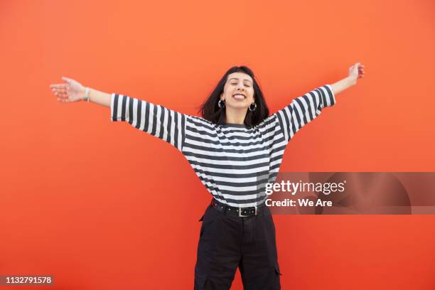 woman in striped top with arms outstretched, smiling. - colour block stock pictures, royalty-free photos & images