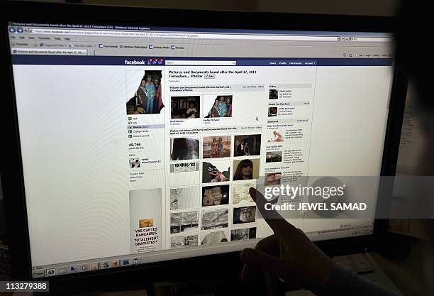 Weather-tornado-society-Internet-Facebook" by Chris LefkowA woman looks at the Facebook page on victims of the killer US tornadoes at an office in...