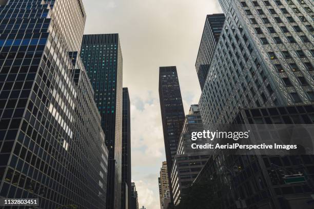 skyscrapers in manhattan - low angle view street stock pictures, royalty-free photos & images