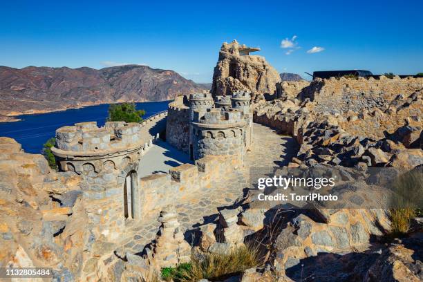 bateria de castillitos - the watchman battery, fortified building with crenelated towers and stone walls in the mountains on the seacoast. cartagena, murcia, spain - murcia spain stock pictures, royalty-free photos & images