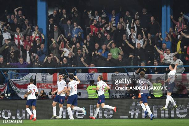 England's defender Michael Keane celebrates with teammates after scoring a goal during the Euro 2020 football qualification match between Montenegro...