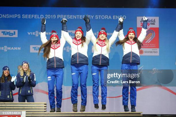 Russias Yulia Belorukova, Anastasia Sedova, Anna Nechaevskaya and Natalia Nepryaeva celebrate their bronze medal following the Women's 4x5km Cross...