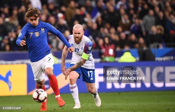 Iceland's midfielder Aron Gunnarsson vies for the ball with France's forward Antoine Griezmann during the UEFA Euro 2020 Group H qualification...
