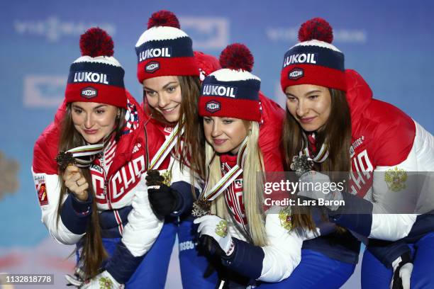 Russias Yulia Belorukova, Anastasia Sedova, Anna Nechaevskaya and Natalia Nepryaeva celebrate their bronze medal following the Women's 4x5km Cross...