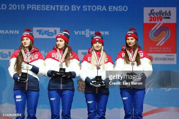 Russias Yulia Belorukova, Anastasia Sedova, Anna Nechaevskaya and Natalia Nepryaeva celebrate their bronze medal following the Women's 4x5km Cross...