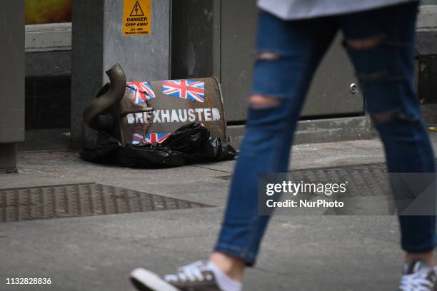 Person passes by a piece of trash art 'Brexhausted' by Irish artist, Frank O'Dea, seen inside The Confession Box pub. This art piece is part of the...