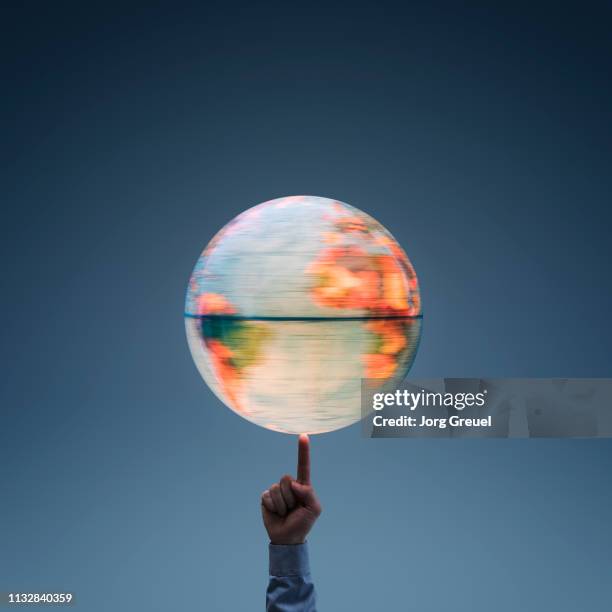rotating globe balancing on finger - rotating world map stock pictures, royalty-free photos & images