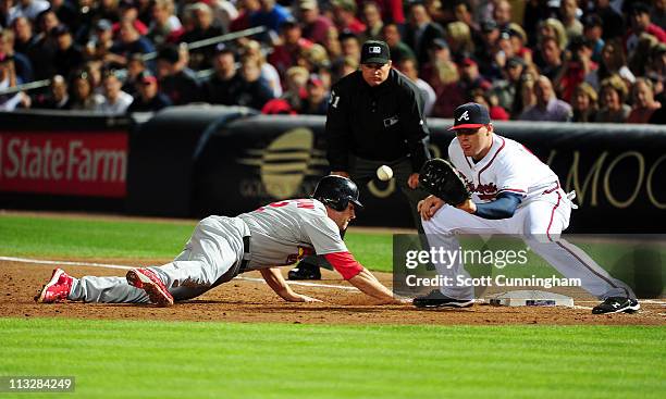 Lance Berkman of the St. Louis Cardinals dives back to first base against Freddie Freeman of the Atlanta Braves at Turner Field on April 29, 2011 in...