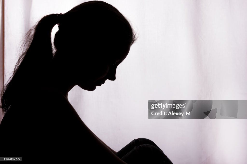 Silhouette of a young woman with problems