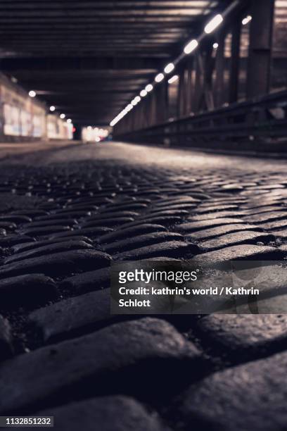 cobblestones in an underpass - lichtquelle fotografías e imágenes de stock