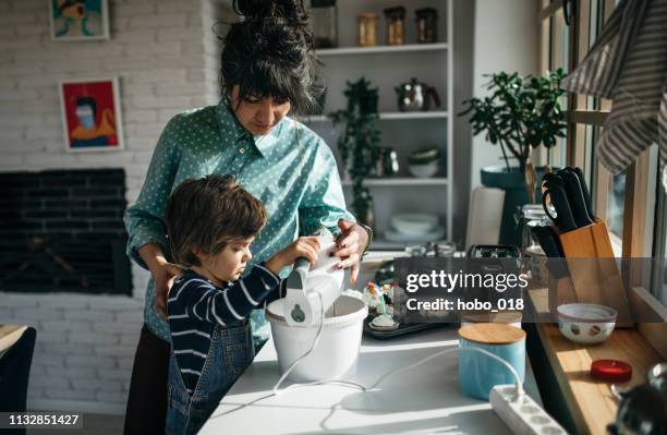 boy assisting his mom in the kitchen - home electricity stock pictures, royalty-free photos & images