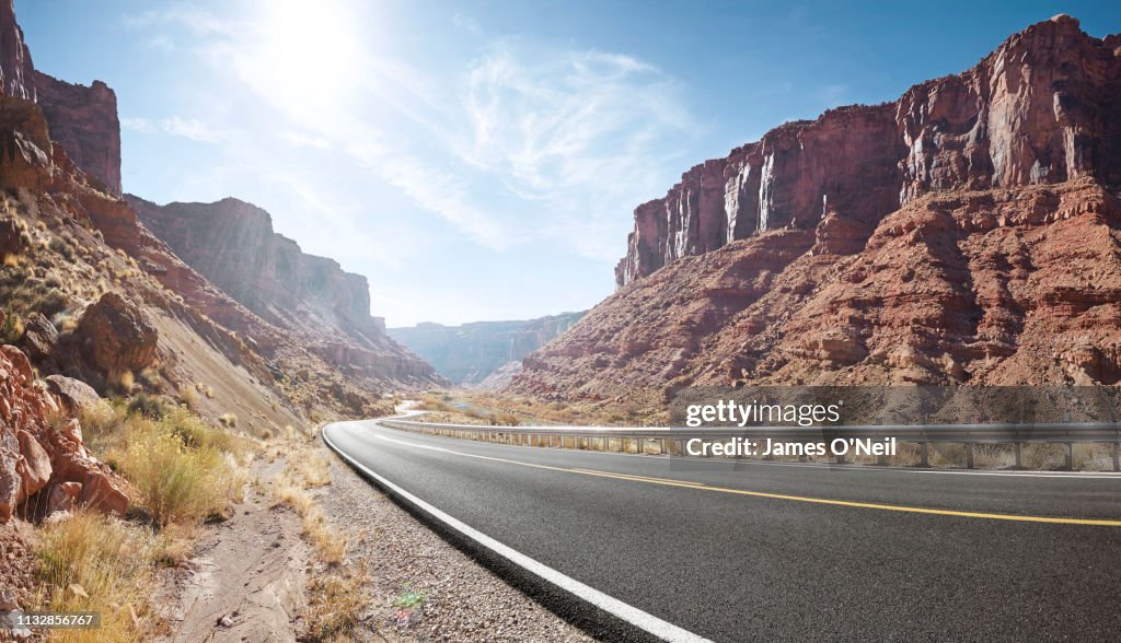 Empty curved road in sandstone cliff valley