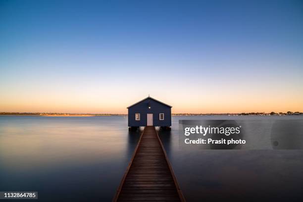 sunset over blue boathouse in the swan river in perth, western australia, australia. - perth western australia stock pictures, royalty-free photos & images