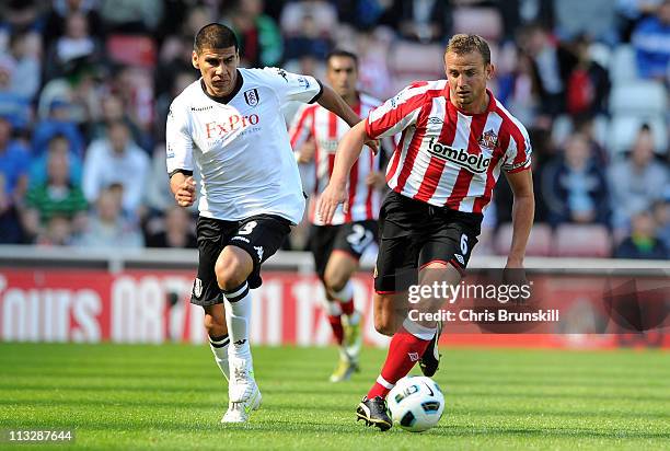 Lee Cattermole of Sunderland is chased by Carlos Salcido of Fulham during the Barclays Premier League match between Sunderland and Fulham at Stadium...