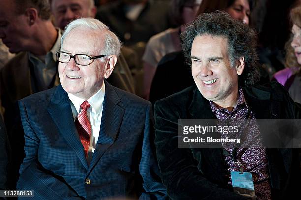 Warren Buffett, chairman of Berkshire Hathaway Inc., left, sits with his son Peter Buffett, prior to the start of the Berkshire Hathaway shareholders...
