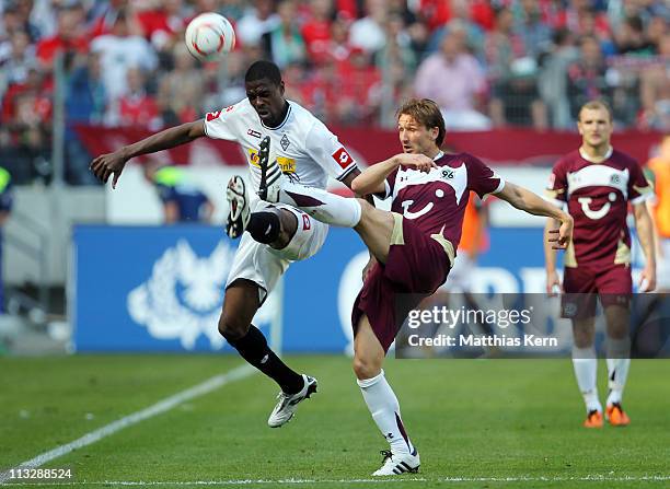 Mohamadou Idrissou of Moenchengladbach battles for the ball with Christian Schulz of Hannover during the Bundesliga match between Hannover 96 and...