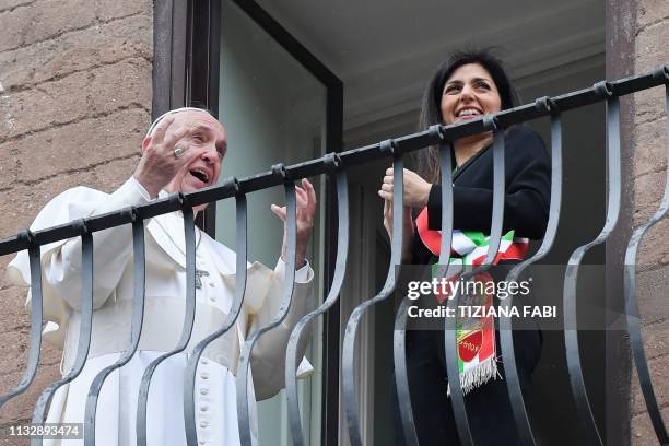 Pope Francis gestures whiles talking with Rome mayor Virginia Raggi as they view over the Roman Forum from a balcony during the Pope's visit to...