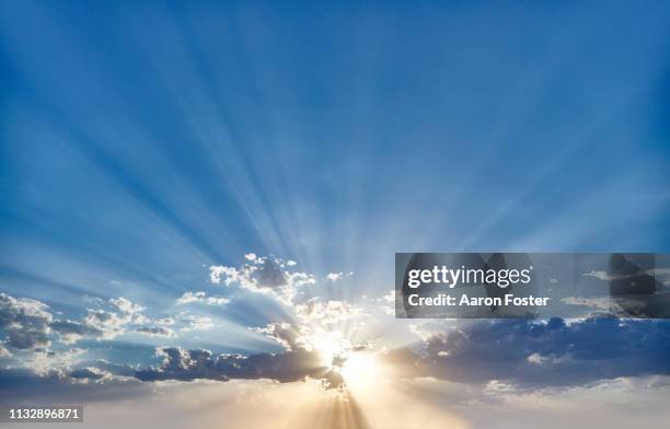 sunset behind clouds - sunbeam ストックフォトと画像