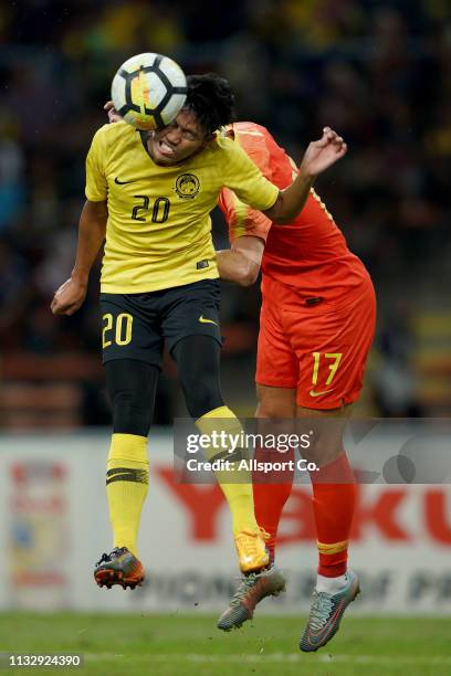 Yang Liyu of China challenges Muhammad Syahmi Safari of Malaysia during the AFC U-23 Championship qualifier between Malaysia and China at Shah Alam...