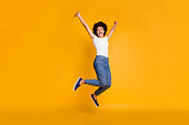 Full length body size side profile photo jumping high beautiful she her lady hands arms up win game play match wearing casual jeans denim white t-shirt clothes isolated yellow bright vivid background
