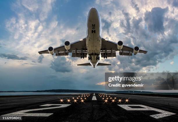 passenger airplane taking off at sunset - plane taking off front view stock pictures, royalty-free photos & images