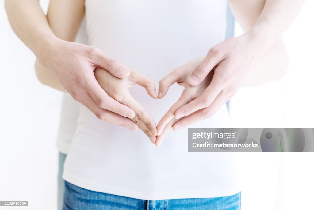 Couple hands making heart shape.