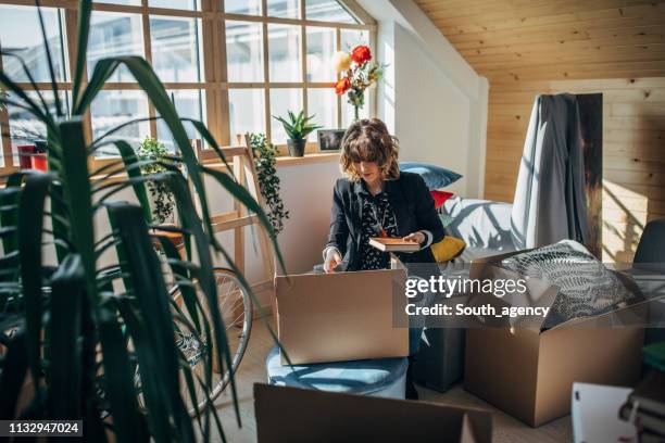 woman moving in into new apartment - mudar de casa imagens e fotografias de stock