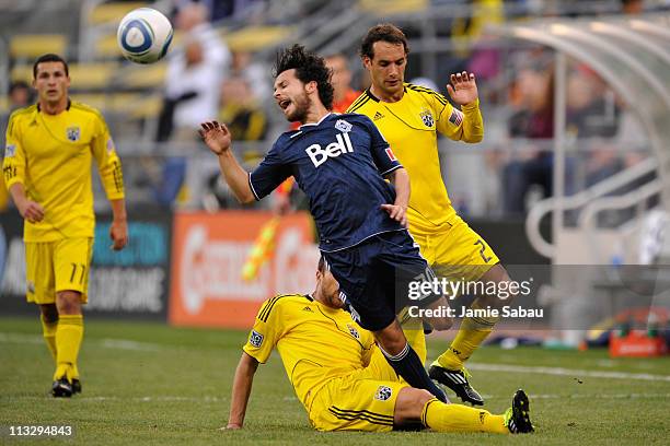 Dejan Rusmir of the Columbus Crew successfully tackles Davide Chiumiento of the Vancouver Whitecaps FC in the first half on April 30, 2011 at Crew...