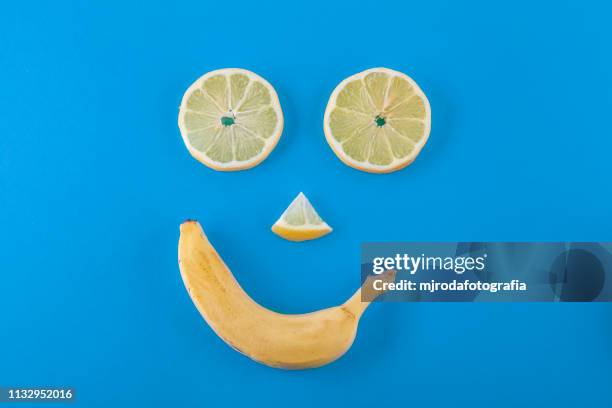 smilling face made with lemons and banana fruits. - comida vegetariana stock pictures, royalty-free photos & images