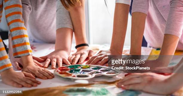 group of children holding hands at the table after drawing - preschool art stock pictures, royalty-free photos & images