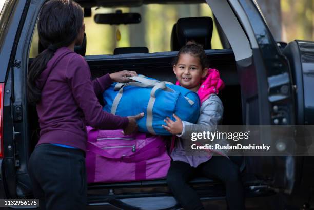 helping mommy loading luggage into car trunk. - car camping luggage imagens e fotografias de stock