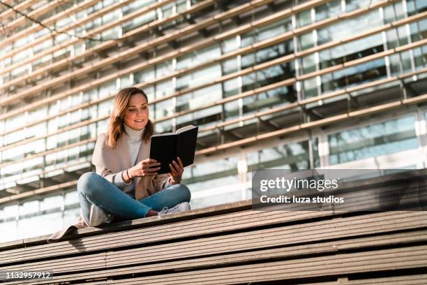 female student is reading a book on campus - gothenburg stock pictures, royalty-free photos & images