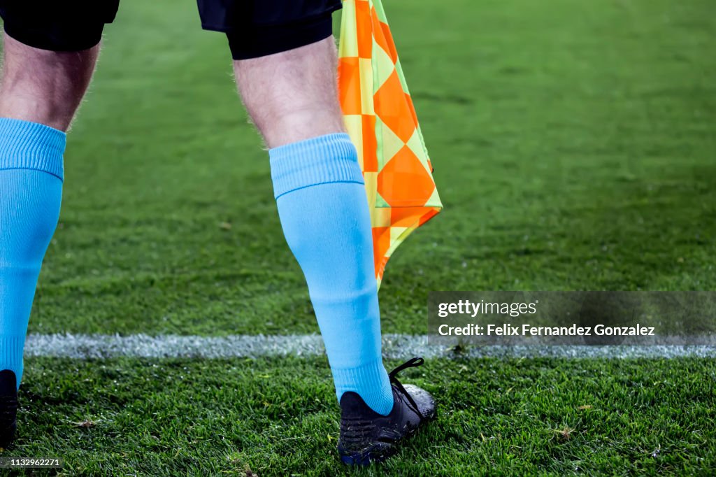 Assistant Referee Signals with flag in the soccer field