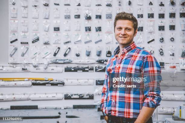 happy young entrepreneur man standing in his store - locksmith stock pictures, royalty-free photos & images