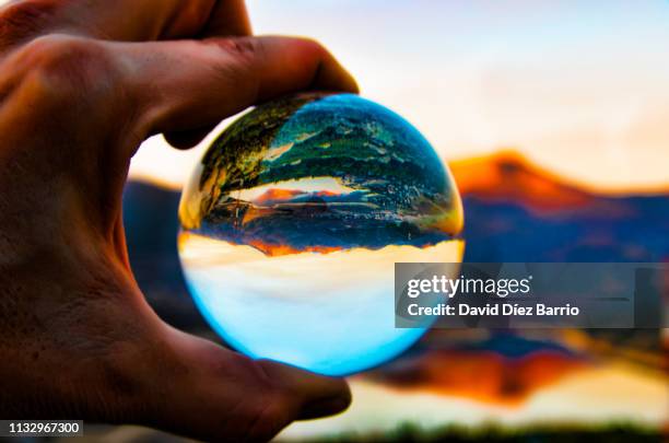 sunset of the mountain 'la maliciosa' reflected in the navacerrada reservoir and all of them reflected in a crystal ball - imaginación bildbanksfoton och bilder