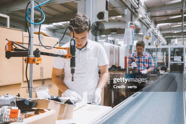 male industry employees work on production line at factory - screwdriver stock pictures, royalty-free photos & images