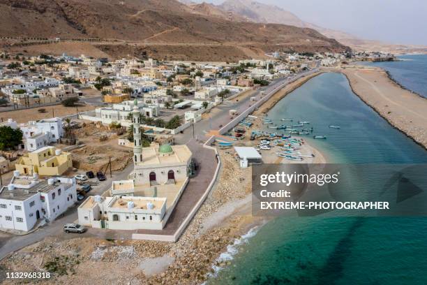 small mosque with a single minaret on the coastal town of tiwi, oman - gulf of oman stock pictures, royalty-free photos & images
