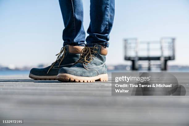 low section of man standing on pier on sunny day in germany. - riemenschuh stock pictures, royalty-free photos & images