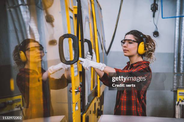 mujer aprendiz de ingeniero trabajando con máquina cnc en fábrica - operational technology fotografías e imágenes de stock