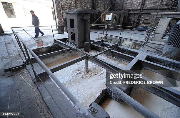 China-commodities-mining-environment by Allison JacksonA worker walks past waste being processed at a privately-owned rare earths factory on April 21...