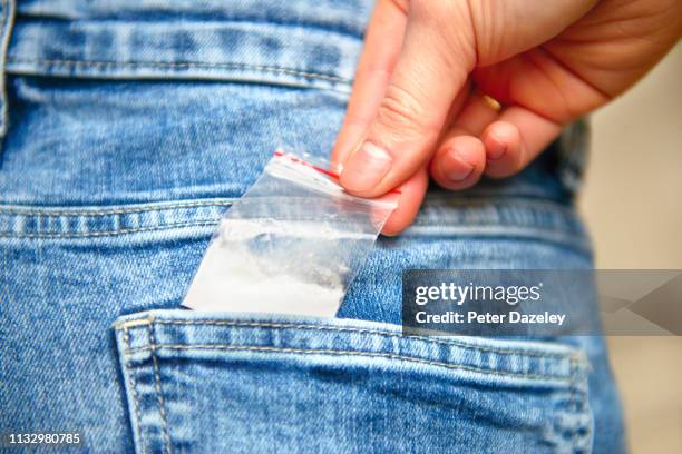 teenage schoolgirl reaching for cocaine in her back jeans pocket - hands in pockets foto e immagini stock