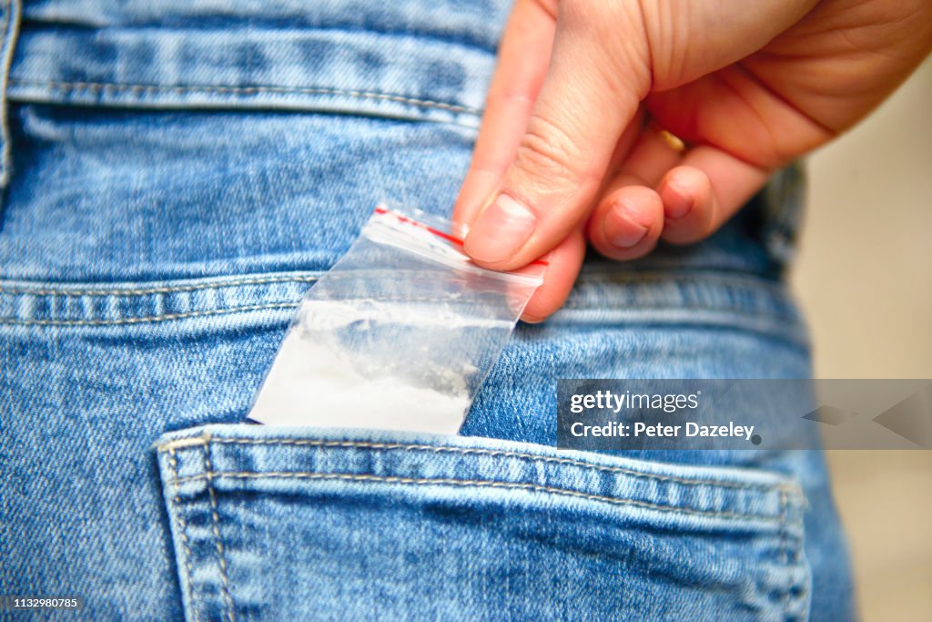 Teenage schoolgirl reaching for cocaine in her back jeans pocket