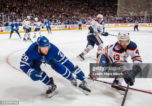 Connor Brown of the Toronto Maple Leafs battles with Josh Currie of the Edmonton Oilers during the third period at the Scotiabank Arena on February...