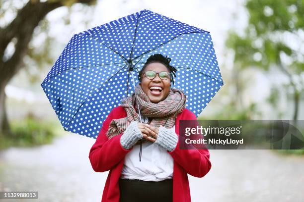 laughing woman with umbrella - holding umbrella stock pictures, royalty-free photos & images