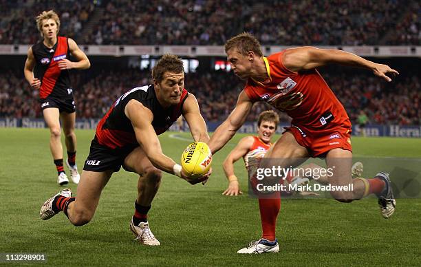 Tom Bellchambers of the Bombers competes with Daniel Harris of the Suns during the round six AFL match between the Essendon Bombers and the Gold...