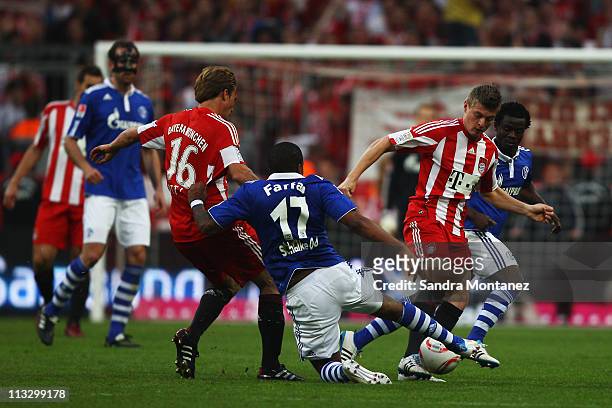 Toni Kroos of Bayern is challenged by Jefferson Farfan and Anthony Annan of Schalke during the Bundesliga match between FC Bayern Muenchen and FC...